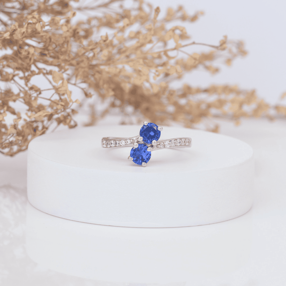 Silver ring with blue gemstones on display